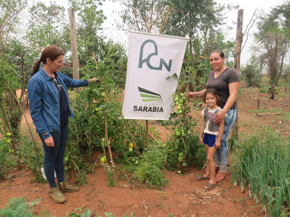 Participantes junto a cultivos de una huerta